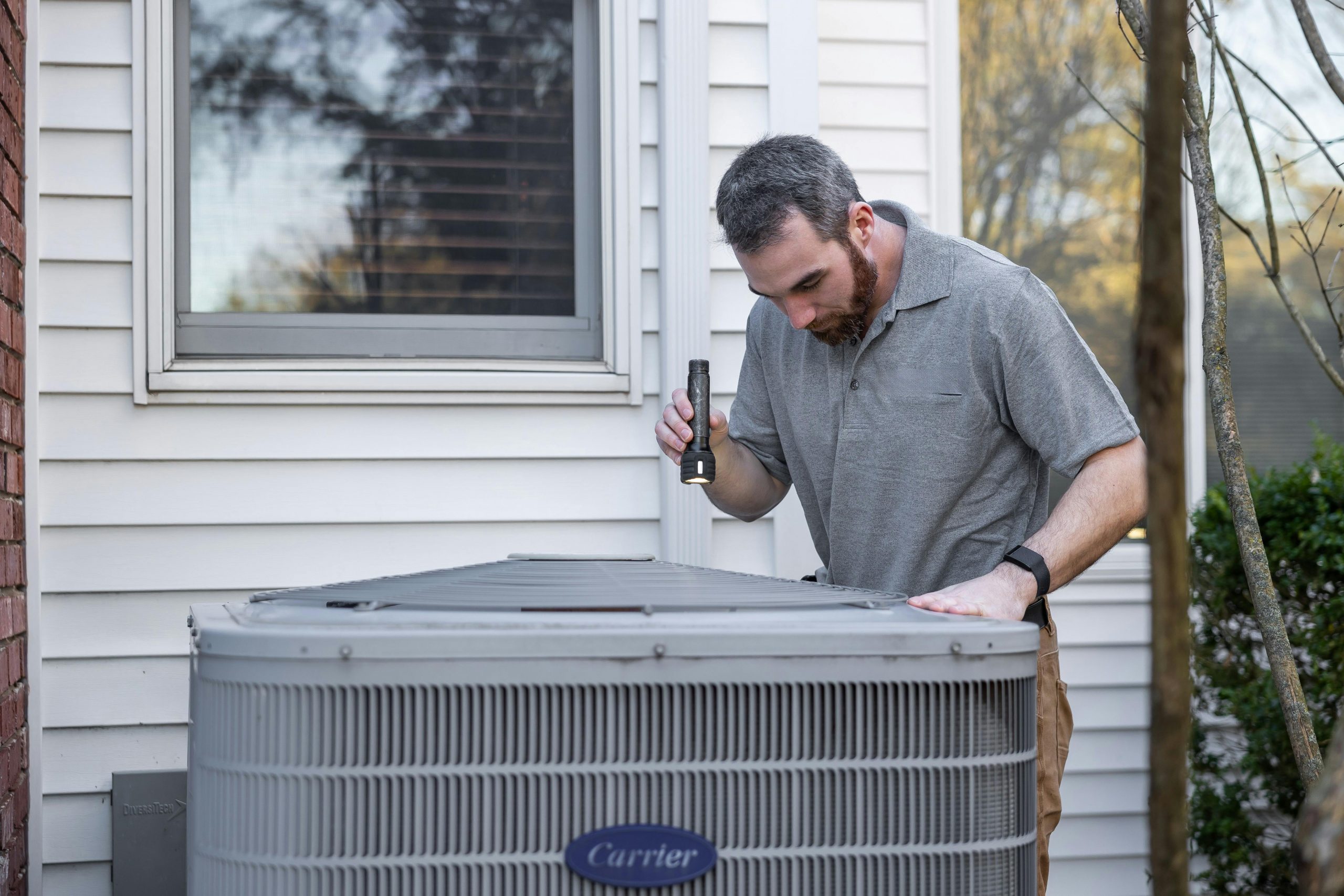 man checking the outdoor air conditioning condenser unit